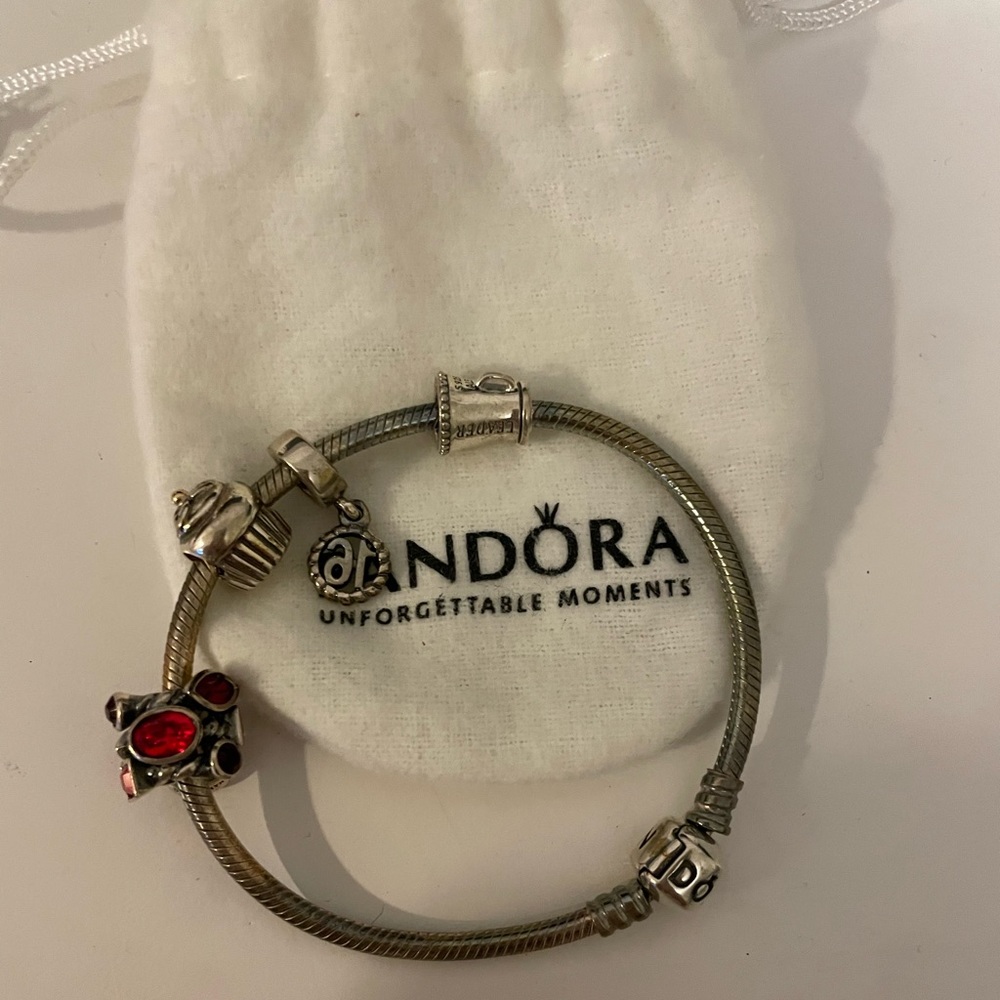Pandora bracelet with ruby birthstone, cupcake, cheer megaphone, & 16th charms.